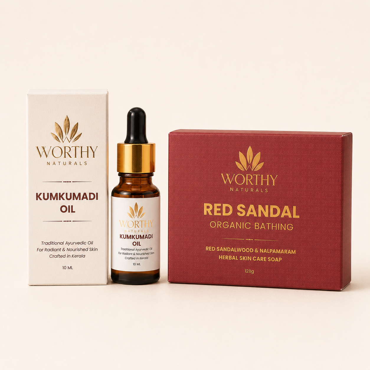 Worthy Naturals skincare set featuring Kumkumadi Oil in an amber glass dropper bottle with a gold collar, shown alongside its off-white box and a dark red box labeled Red Sandal Organic Bathing, on a warm cream background.